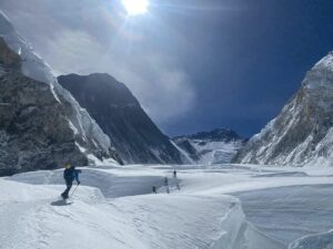 wide open mountain area with snow and a few backlit climbers